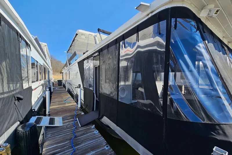 Slide: The Image of 2001 Sumerset 16x79 houseboat docked with protective coverings and clear blue sky. - 1