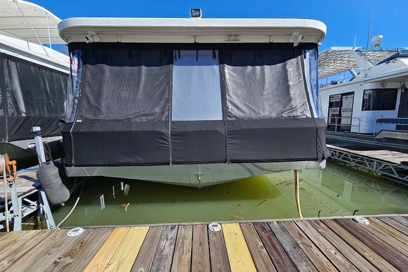 Slide: The Image of 2001 Sumerset 16x79 houseboat docked with covered windows and calm water. - 2