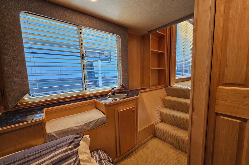 Slide: The Image of Interior of a 2001 Sumerset 16x79 houseboat with wooden cabinetry and window blinds. - 22