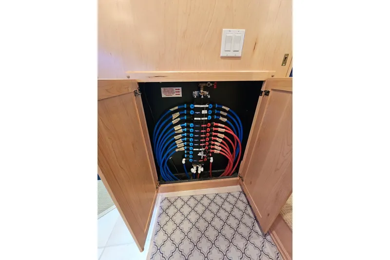 Slide: The Image of Plumbing system inside a 2001 Sumerset 16x79 houseboat, featuring organized blue and red pipes. - 26