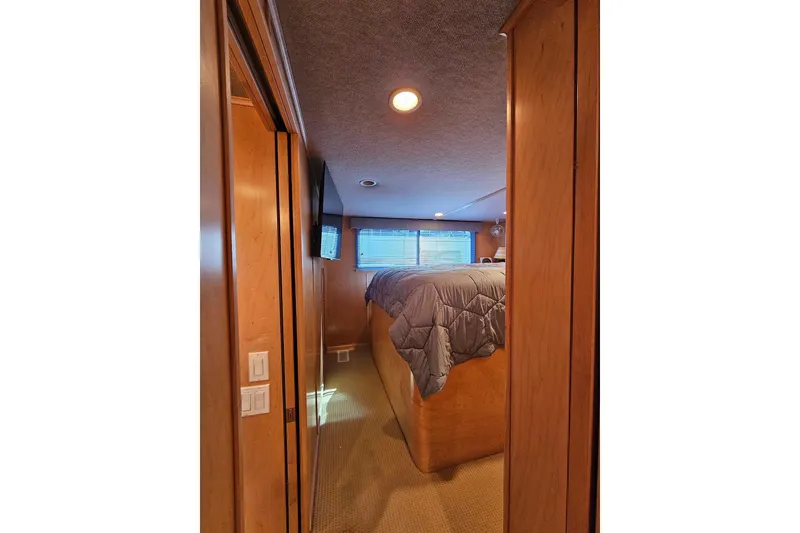 Slide: The Image of Cozy bedroom interior of 2001 Sumerset 16x79 houseboat with wood paneling and natural light. - 27