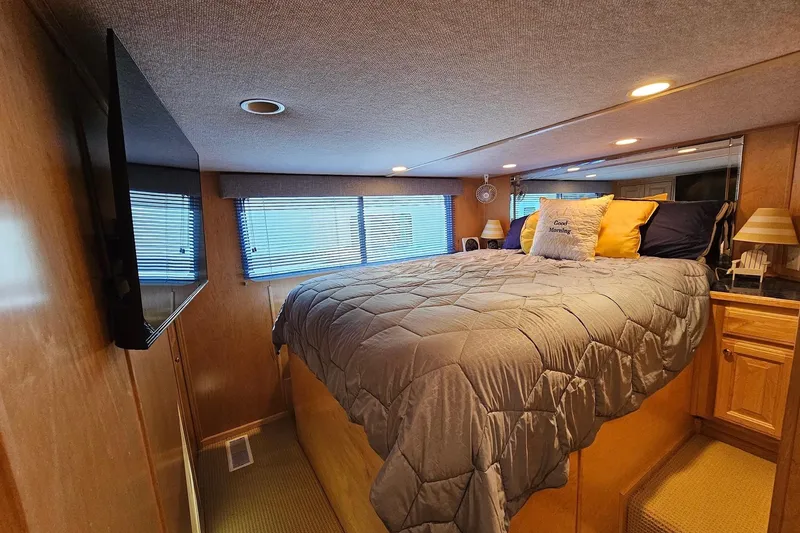 Slide: The Image of Cozy bedroom in 2001 Sumerset 16x79 houseboat with TV and plush bedding. - 28