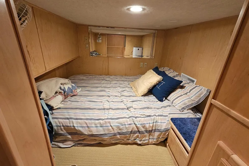 Slide: The Image of Cozy bedroom in a 2001 Sumerset 16x79 houseboat with striped bedding and wooden interior. - 37