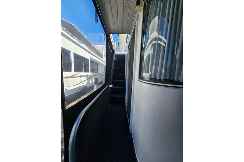 Slide: The Image of Narrow walkway on a 2001 Sumerset 16x79 houseboat with stairs and window view. - 4