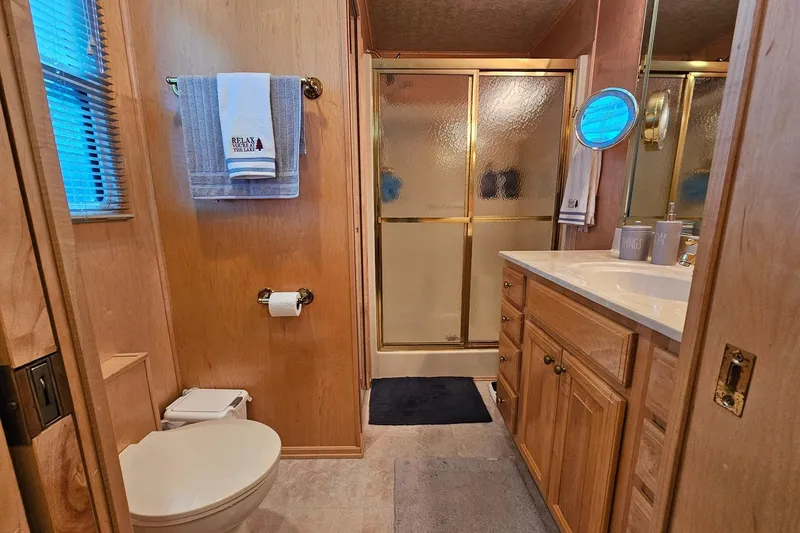 Slide: The Image of Bathroom in 2001 Sumerset 16x79 houseboat with wooden cabinetry and glass shower doors. - 45
