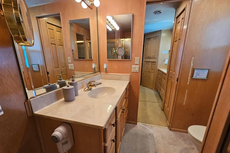 Slide: The Image of Luxurious bathroom in a 2001 Sumerset 16x79 houseboat with wooden cabinetry and modern fixtures. - 46