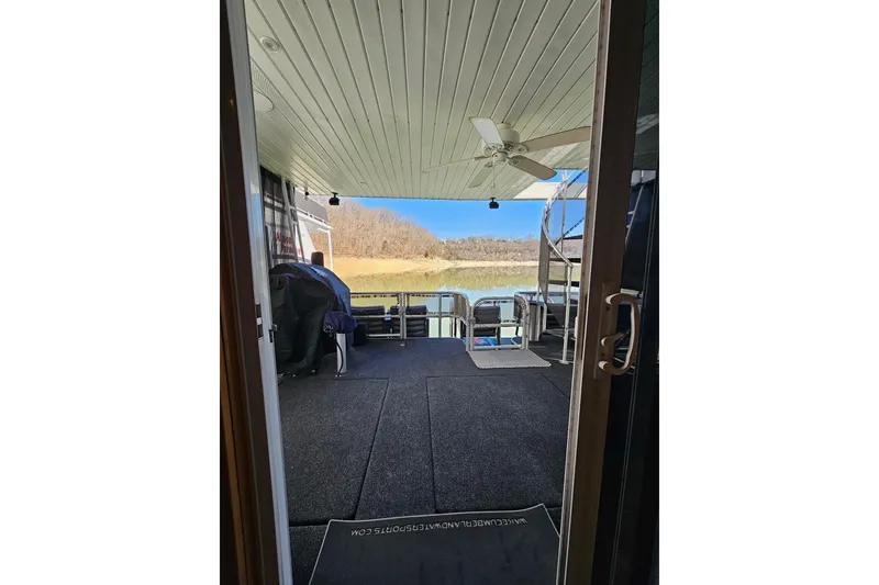 Slide: The Image of Covered deck view of 2001 Sumerset 16x79 houseboat with outdoor seating and scenic backdrop. - 47