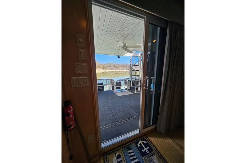 Slide: The Image of View from inside a 2001 Sumerset 16x79 houseboat, showing a deck with outdoor seating. - 48