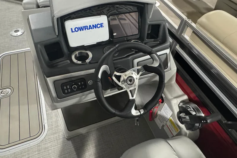 Slide: The Image of 2025 Regency 230 DL3 boat dashboard with steering wheel and Lowrance display. - 10