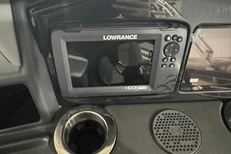 Slide: The Image of Lowrance Hook Reveal GPS on 2025 Regency 230 DL3 dashboard with cup holder and speaker. - 11