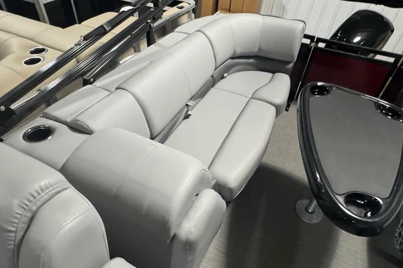 Slide: The Image of Luxurious seating on 2025 Regency 230 DL3 pontoon boat with cup holders and table. - 13