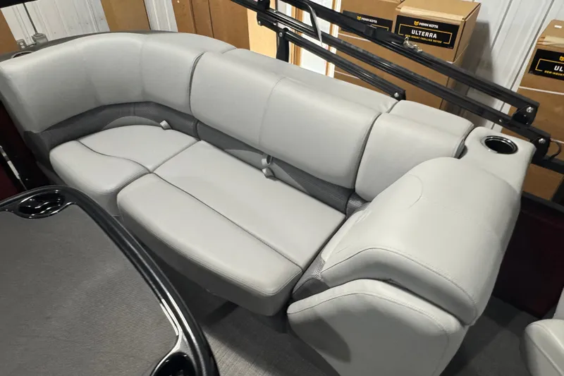Slide: The Image of Luxurious seating in 2025 Regency 230 DL3 boat, featuring plush gray upholstery and cup holders. - 14