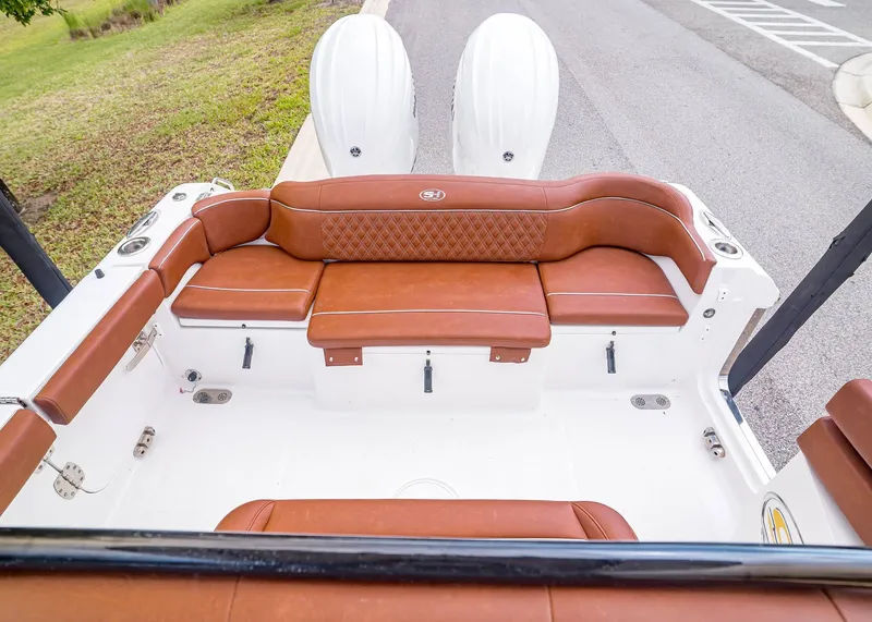 Slide: The Image of 2024 Sea Hunt Ultra 265 SE boat rear seating with brown upholstery. - 5