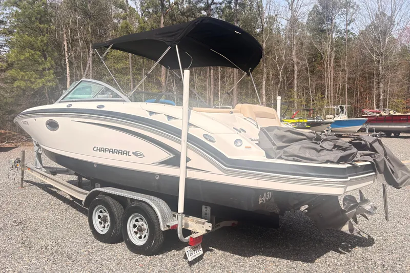 Slide: The Image of 2011 Chaparral 244 Sunesta boat on trailer, parked outdoors with canopy. - 1