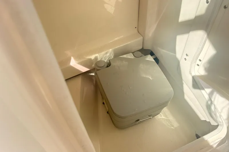 Slide: The Image of Portable toilet inside 2011 Chaparral 244 Sunesta boat cabin, illuminated by sunlight. - 11