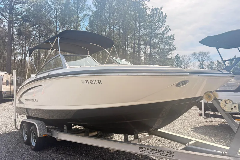 Slide: The Image of 2011 Chaparral 244 Sunesta boat on trailer, parked outdoors with trees in background. - 3