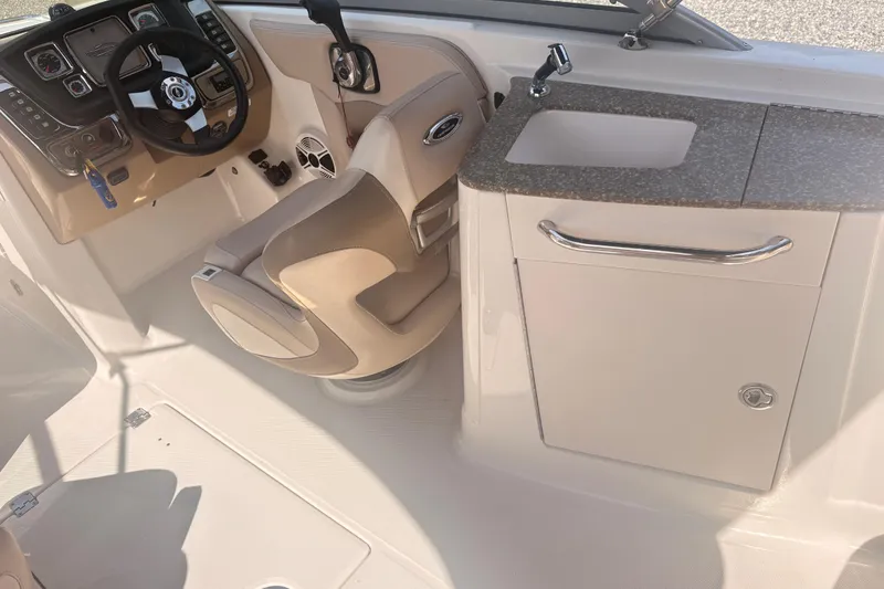 Slide: The Image of Interior of 2011 Chaparral 244 Sunesta boat with steering wheel and sink area. - 6