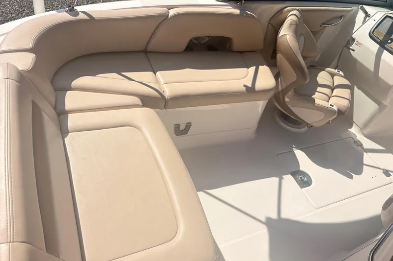 Slide: The Image of 2011 Chaparral 244 Sunesta boat interior with beige seating and helm chair. - 7