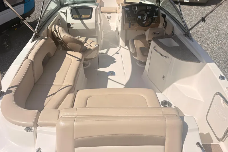 Slide: The Image of 2011 Chaparral 244 Sunesta boat interior with beige seating and steering console. - 8
