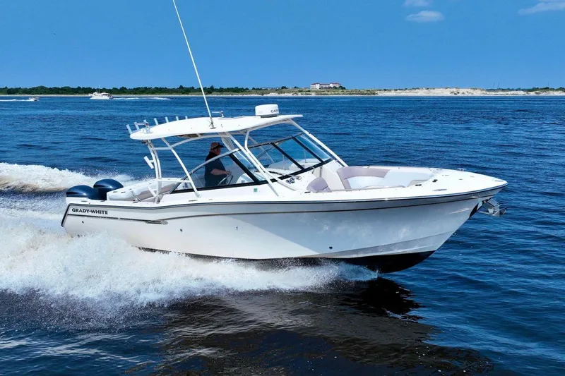 The Image of 2013 Grady-White Freedom 307 boat cruising on open water under clear blue sky. - 1