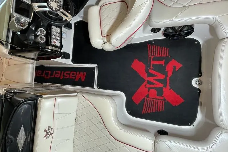 Slide: The Image of Interior of a 2010 MasterCraft XStar boat with white seats and custom floor mat. - 10