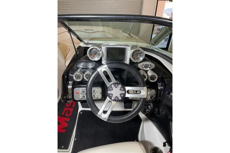 Slide: The Image of Steering wheel and dashboard of a 2010 MasterCraft XStar boat. - 12