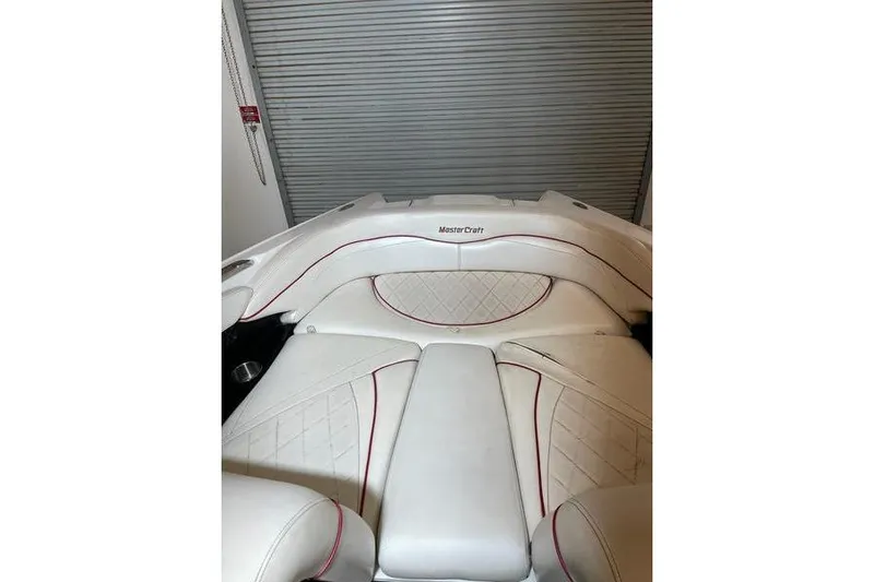 Slide: The Image of 2010 MasterCraft XStar boat interior with white leather seats and red accents. - 6