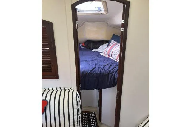 Slide: The Image of Cozy cabin interior of 2000 Hunter 340 sailboat with bed and striped bedding. - 11