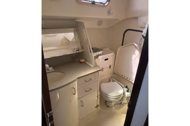 Slide: The Image of Interior of 2000 Hunter 340 sailboat bathroom with sink, toilet, and storage cabinets. - 12