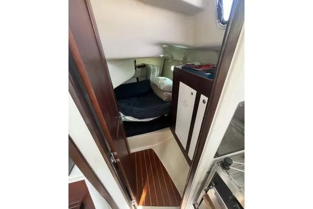 Slide: The Image of Cozy cabin interior of 2000 Hunter 340 sailboat with wooden accents and bedding. - 14