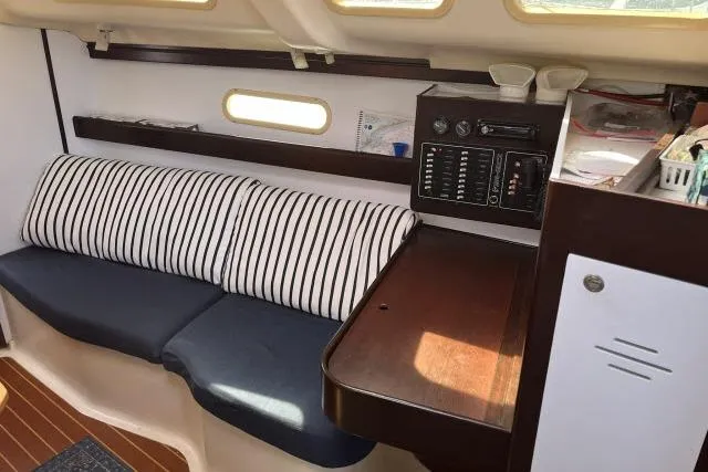Slide: The Image of Interior of 2000 Hunter 340 sailboat with striped cushions and wooden table. - 4
