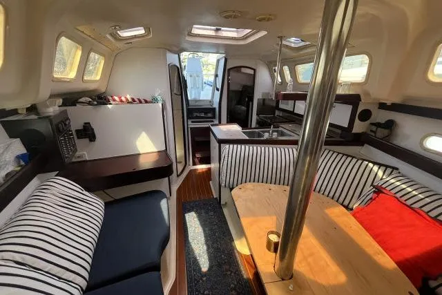 Slide: The Image of Interior of a 2000 Hunter 340 sailboat with striped seating and wooden accents. - 6