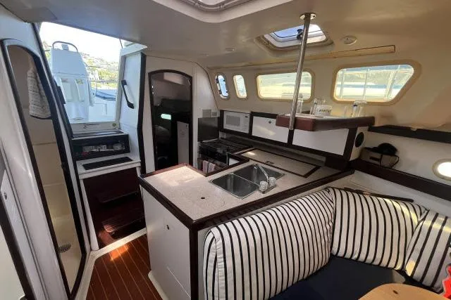 Slide: The Image of Interior of a 2000 Hunter 340 sailboat with kitchen and seating area. - 8