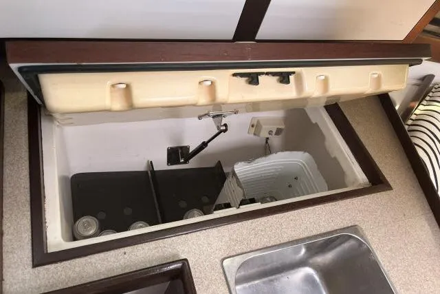 Slide: The Image of Open storage compartment in 2000 Hunter 340 boat interior, featuring a sink and countertop. - 9