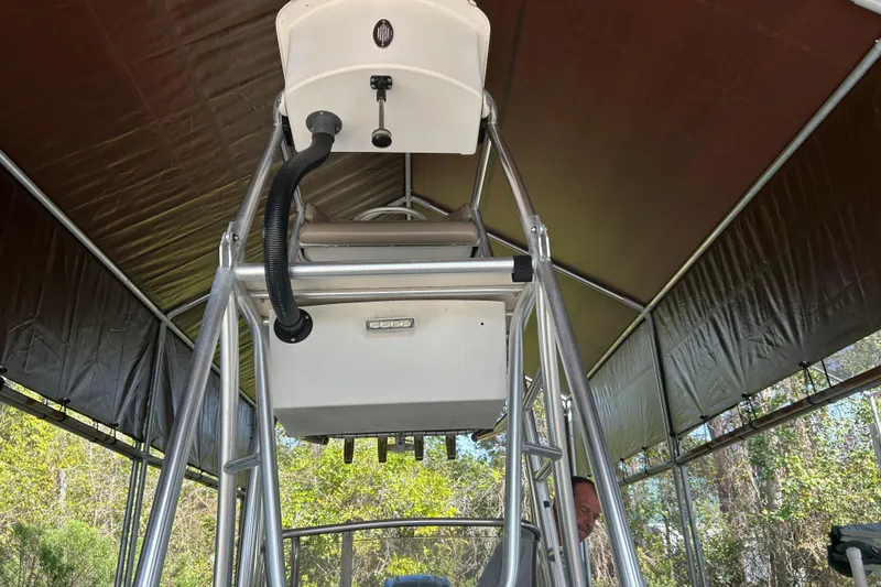 Slide: The Image of 2006 Scout 240 Bay Scout boat under canopy, showcasing tower and equipment. - 4