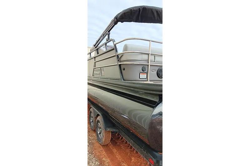 Slide: The Image of 2024 Ranger 2500LS pontoon boat on trailer, side view with railing and wheels visible. - 10