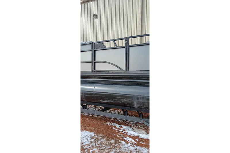 Slide: The Image of 2024 Ranger 2500LS pontoon boat beside a metal building, on snowy ground. - 16