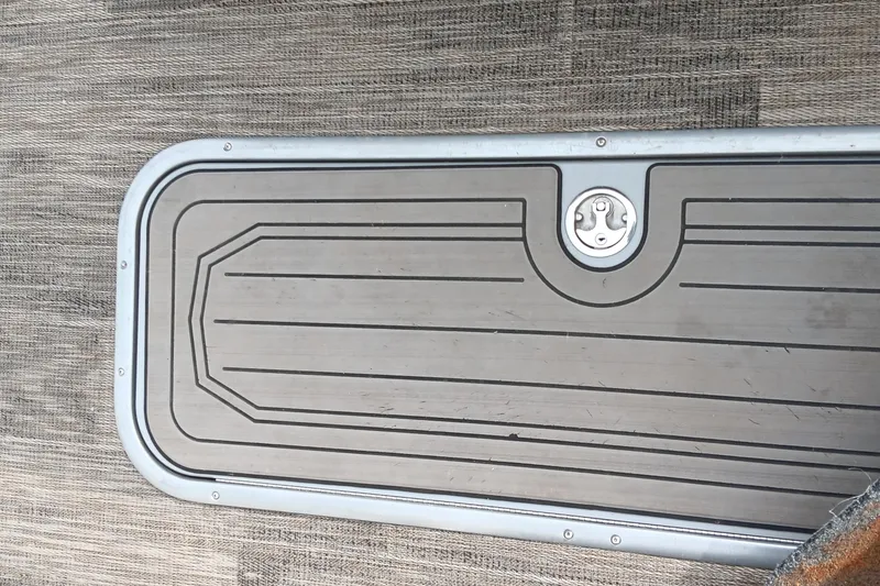 Slide: The Image of 2024 Ranger 2500LS boat deck with textured surface and metal latch. - 28