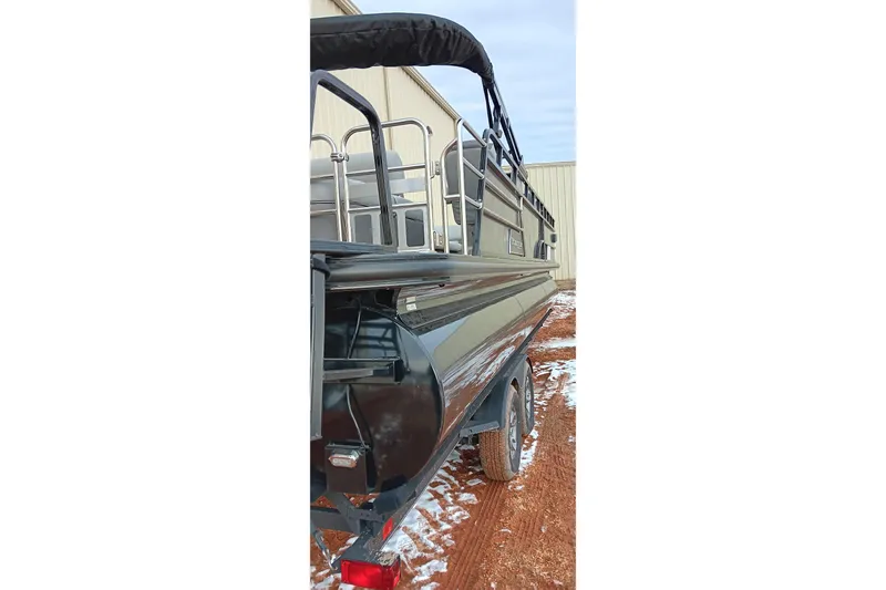 Slide: The Image of 2024 Ranger 2500LS boat on trailer, parked on snowy ground near a building. - 4