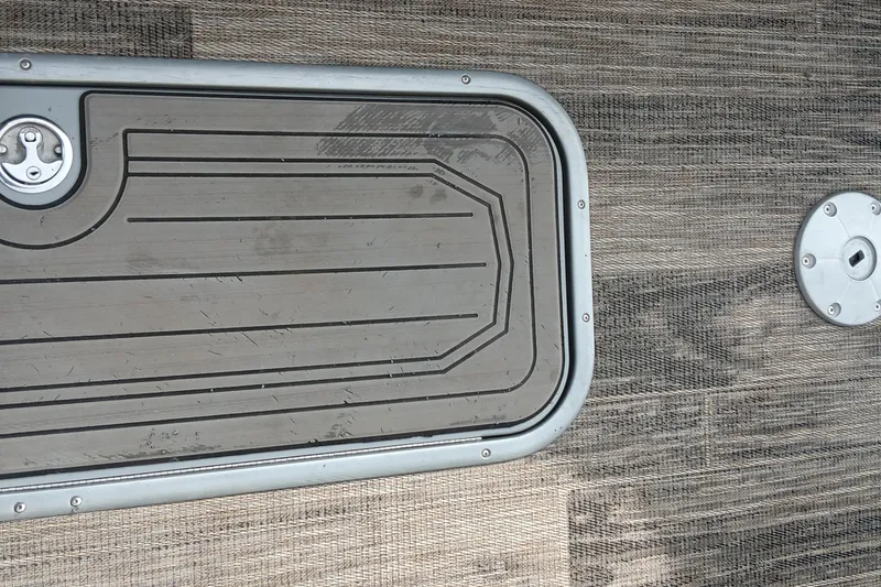 Slide: The Image of 2024 Ranger 2500LS boat deck with textured flooring and metal hatch. - 43