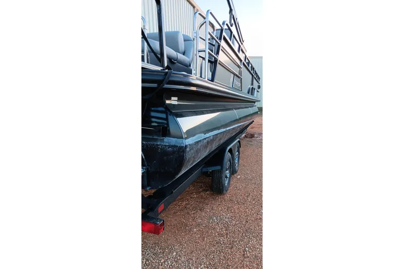 Slide: The Image of 2024 Ranger 2500LS boat on trailer, side view, parked on gravel. - 49