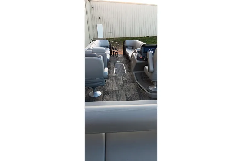 Slide: The Image of 2024 Ranger 2500LS boat interior with gray seating and wood-style flooring. - 56