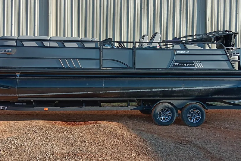 Slide: The Image of 2024 Ranger 2500LS pontoon boat on trailer, parked outdoors. - 72