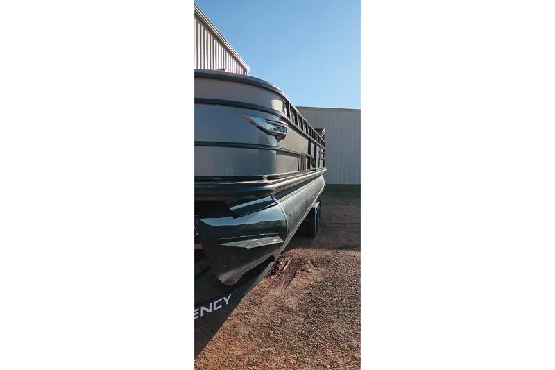Slide: The Image of 2024 Ranger 2500LS pontoon boat parked outdoors near a building. - 74