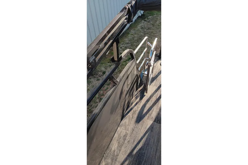 Slide: The Image of 2024 Ranger 2500LS boat deck with railing and ladder, outdoor setting. - 83