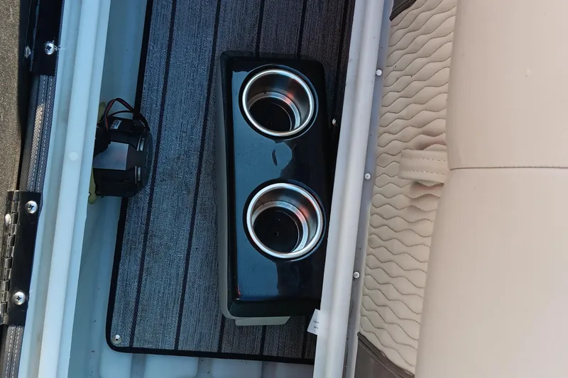 Slide: The Image of 2024 Ranger 2500LS boat interior with cup holders and beige seating. - 87