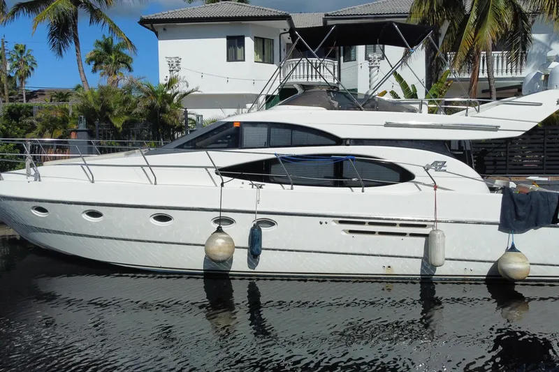 Slide: The Image of 1998 Azimut 52 yacht docked by a tropical waterfront home. - 22