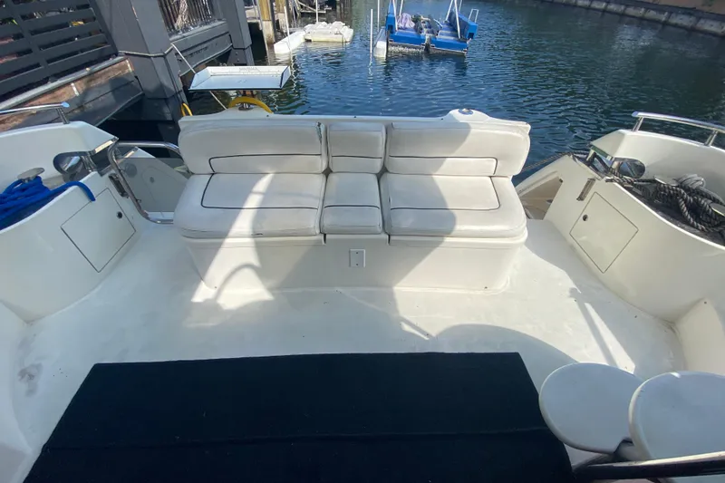 Slide: The Image of 1998 Azimut 52 yacht deck with white seating, docked by the water. - 24