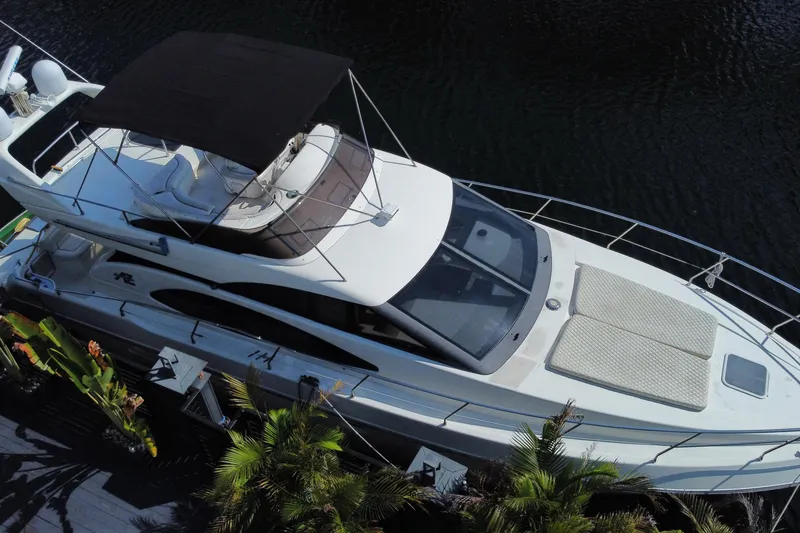 Slide: The Image of 1998 Azimut 52 yacht docked, aerial view showcasing sleek design and spacious deck. - 4