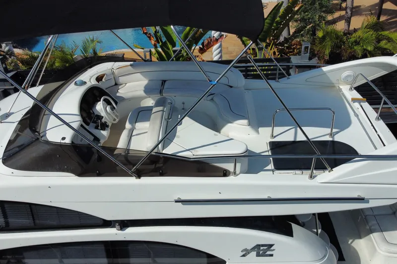 Slide: The Image of 1998 Azimut 52 yacht flybridge with seating and steering wheel, surrounded by tropical plants. - 47